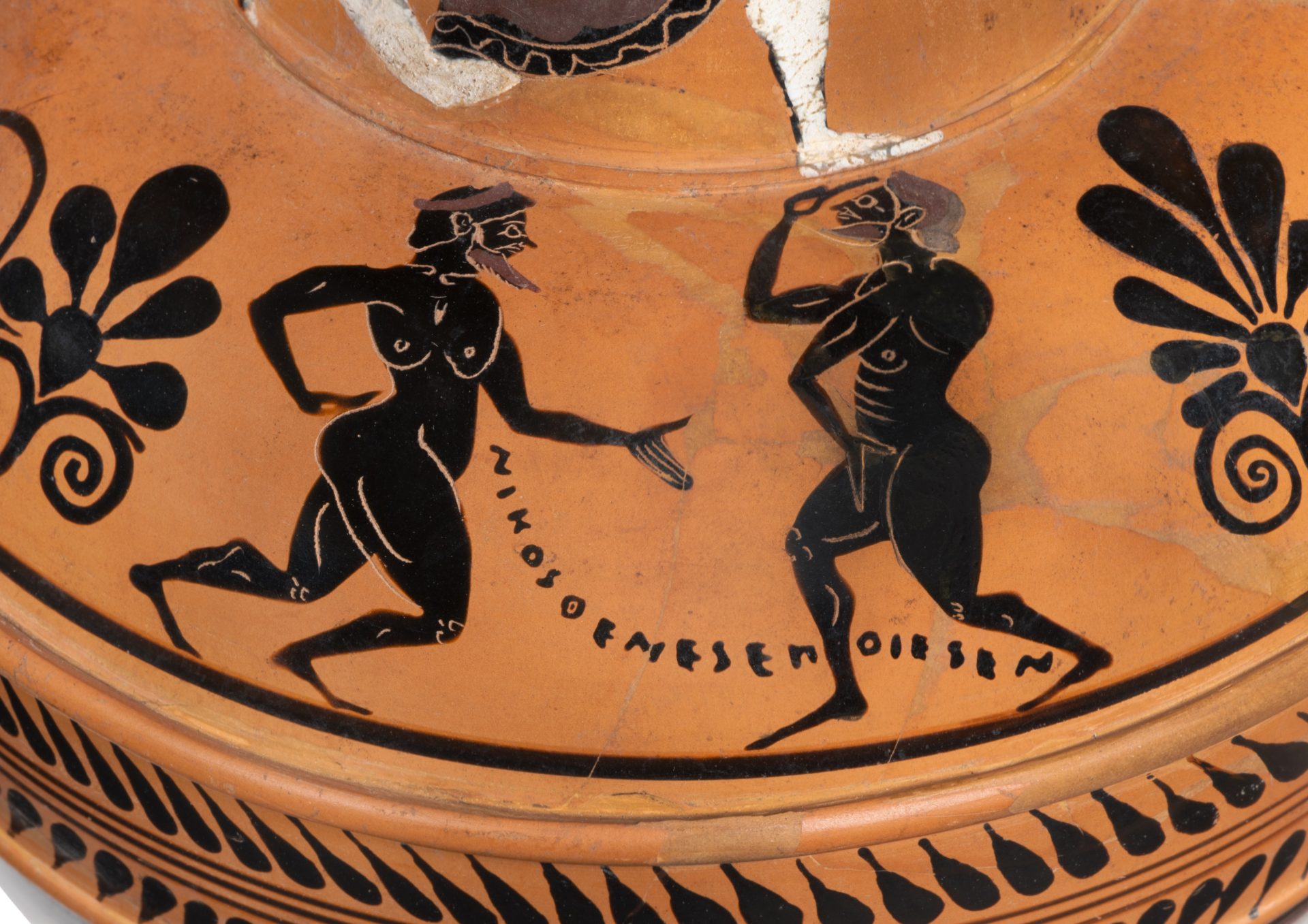 Antike griechische Vase mit schwarzfiguriger Darstellung von zwei in Bewegung befindlichen nackten Figuren.