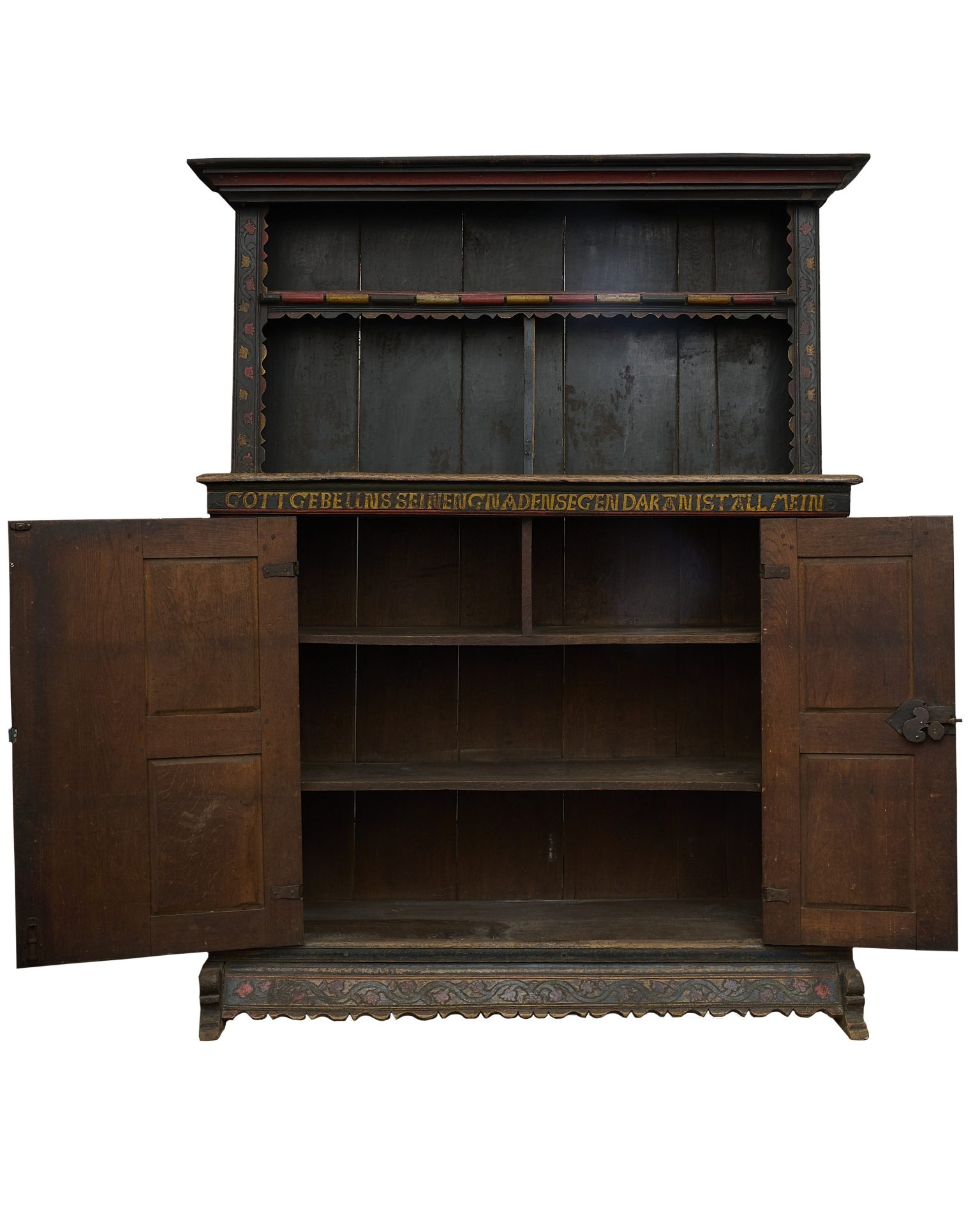 Antiker, dunkler Holzschrank mit offenen Türen, dekorativen Elementen und einer Aufschrift auf der Oberseite.