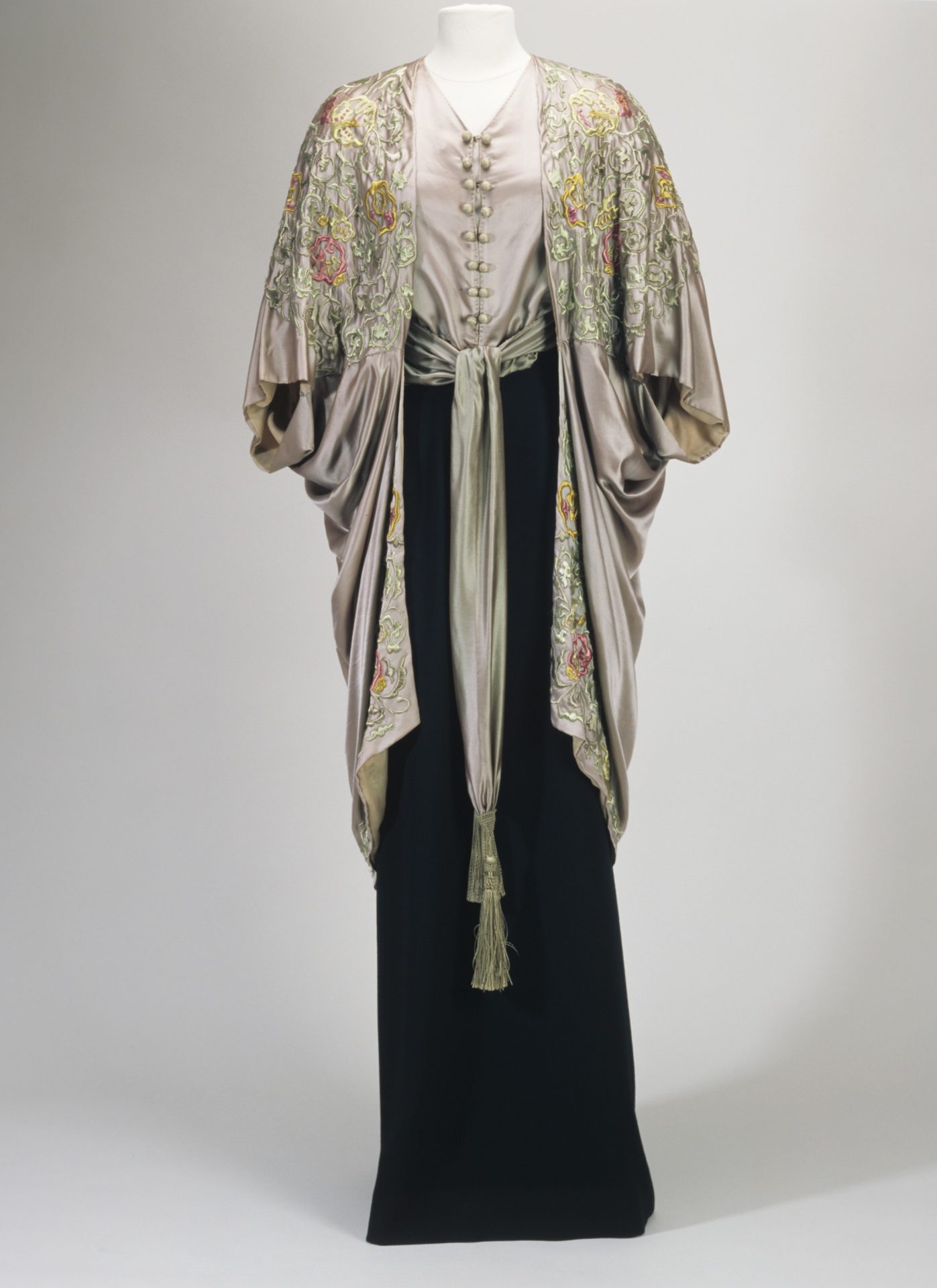 Elegantes Kleid mit besticktem, schimmerndem Oberteil und langem, schwarzem Rock. Kunstvolle Details und stilvolle Formen.