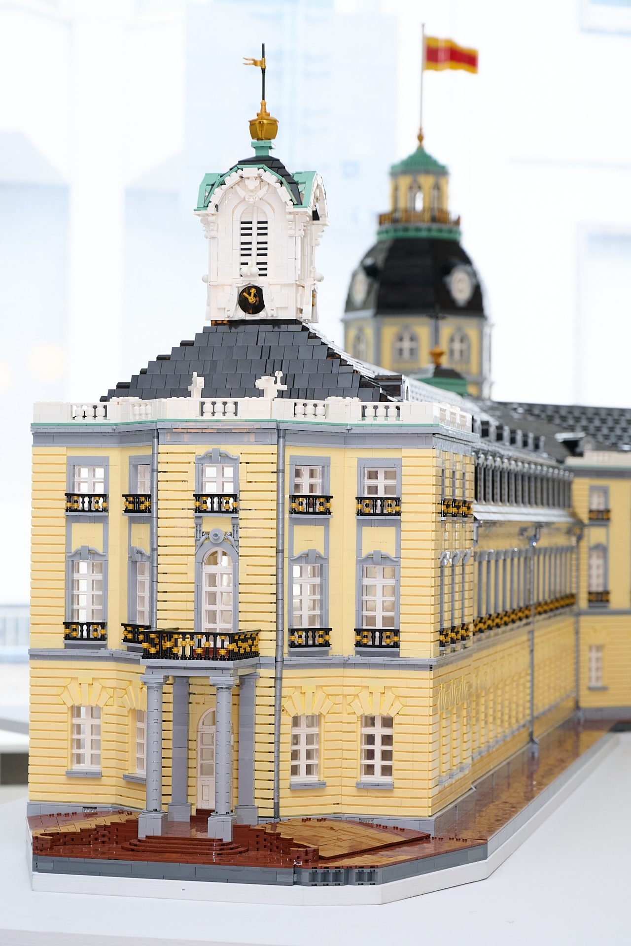 Detaillierte LEGO-Nachbildung eines historischen Gebäudes mit gelber Fassade und Turm.